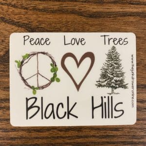 Black hills sticker with a wooden peace sign, heart, and a tree design.