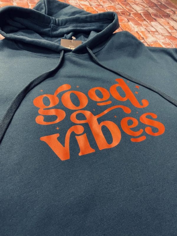 Angled close up view of orange good vibes text