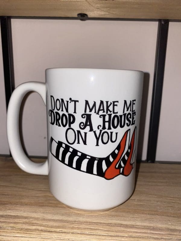 Custom mug with don't make me drop a house on you text above stripped leggings with red color heels