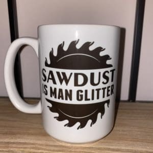Custom mug with a sawblade split in the middle with sawdust is man glitter text