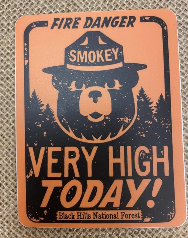 Orange Fire Danger sign with Smokey the Bear and Very High Today! above Black Hills National Forest sticker