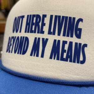 LIVING BEYOND MY MEANS TRUCKER HAT