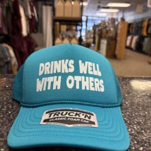 DRINKS WELL WITH OTHERS TRUCKER HAT